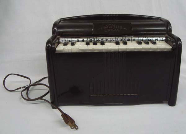 Vintage Mangus Bakelite Toy Organ Model 1510: Vintage Mangus Bakelite Toy Organ Model 1510. Electric, and still plays. Mangus Harmonica Corporation. Two keys have end damage, but what a sweet toy of the past. 7''H x 11''L x 6'' W.