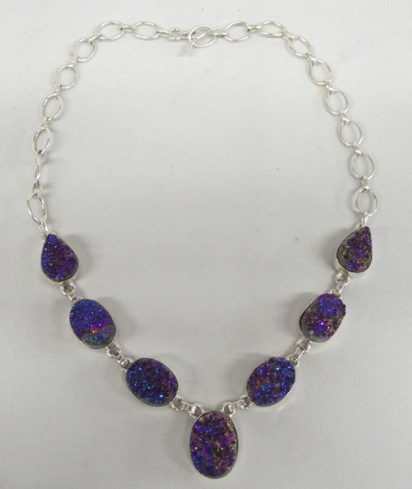 Titanium Peacock Druzy Necklace: Titanium Peacock Druzy Necklace. Seven ovals with druzy sets, largest oval is 7/8''L x 5/8''W. Total length 18''. Adjustable length with curved toggle clasp. Sparkles in the light with any small movem