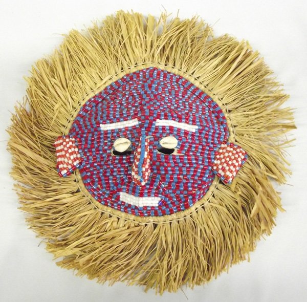 African Ivory Coast Beaded Mask with Straw Fringe: African Ivory Coast Beaded Mask with Straw Fringe.For African ceremonies, this mask has ties on the cloth back and is 12.75'' diameter. Red, white and blue beads with shell over eye holes.