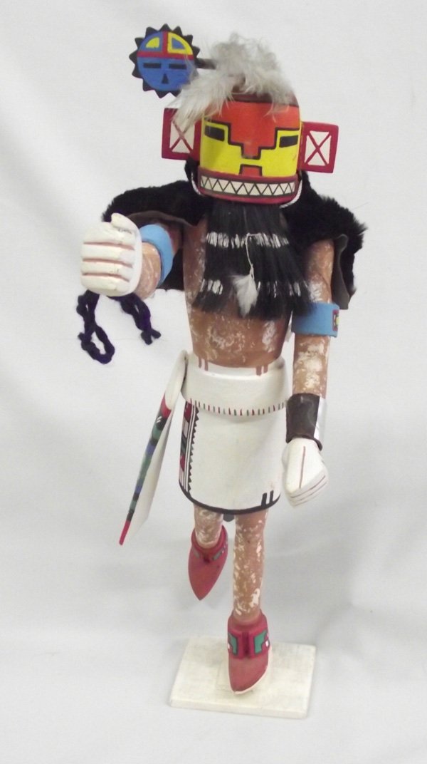 Hopi Hand Carved Wooden Kachina: Native American Hopi Kachina. This kachina has a long grey tail and a sun face on his mask. He wears hand painted dance skirt. Both his legs have been broken and repaired. He is 15.5''H x 6''W.
