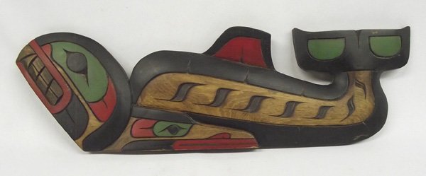 Northwest Coast Killer Whale Wall Plaque E Ashley: Northwest Coast Killer Whale Wall Plaque E Ashley. Solid wood carved whale figure with black, green and red painted features. Signed on the back, ''Killer Whale by Earl Ashley.'' Measures 18.75''Lx6''