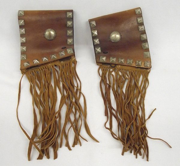Studded Leather Fringed Wrist Cuffs: Studded Leather Fringed Wrist Cuffs. 5''L x 4.5''W. Lace up cuffs with fringe. Leather wrist cuffs were used during the late 1800's to protect cowboy's wrists from rope burns, brush scrapes, cow kicks