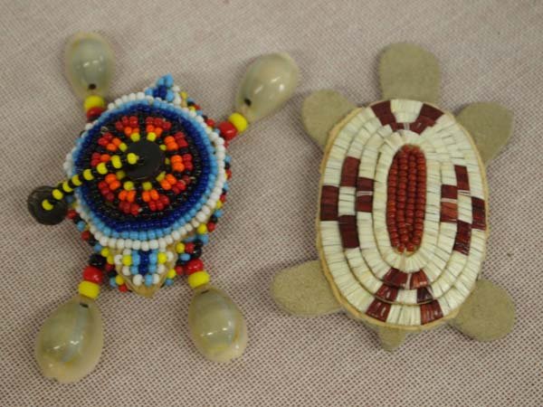 Two Iriquois Beaded Turtle Fetishes: Two Iriquois Beaded Turtle Fetishes. Iriquois fetishes made from cowrie shells and porcupine quills and tiny beads. The white and red turtle measures 3'' long x 2'' wide.