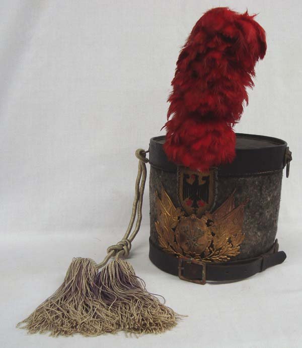 Antique Military Leather Felt Plume Hat: Antique Military Leather Felt Plume Hat. This tall hat is felt wrapped with a brass flag emblem on the front as well as a cloth eagle designs. the plume is red feathers. The top has leather trim with 