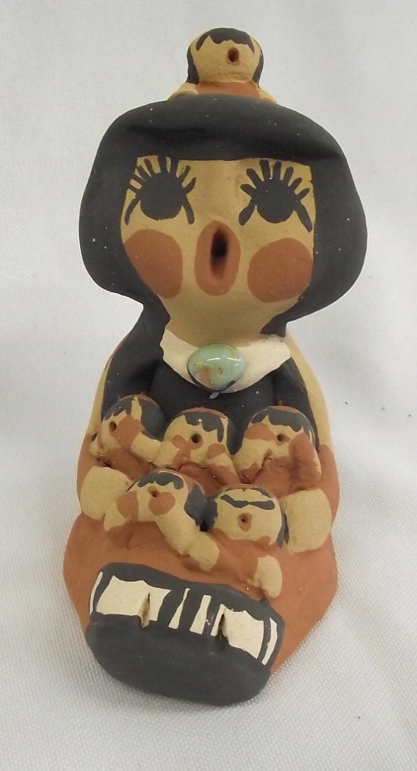Jemez Pottery Storyteller - Caroline Sando: Jemez Pottery Storyteller - Caroline Sando. This storyteller has six babies singing along with her. She is signed on the bottom, Caroline Sando and measures 3''H x 2''D x 3.5''W. A single turquoise nu
