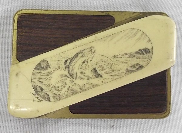 Vintage Belt Buckle Knife: Vintage Belt Buckle Knife. Hidden behind the bone with the fish drawing is a Gerber knife blade. The fish drawing is signed ''Blair''. The buckle is brass with wood inlay. It measures 2-5/8''L x 1-3/4