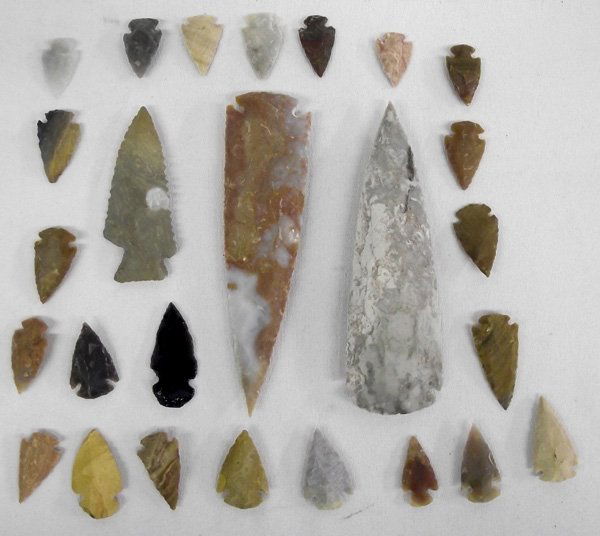 Stone Arrowheads and Spears: Stone Arrowheads and Spears. Collection of over 25 stone dovetail points, age and origin unknown. The largest spear is 5.5''L x 1.75''W. The largest arrowhead is an obsidian arrowhead that is 2''L x 1