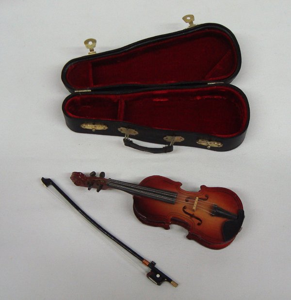 Miniature Violin and Hard Shell Case: Miniature Violin and Hard Shell Case. Incredible miniature wood violin with strings, pegs that the strings really attach to, a bow and a hard shell case with brass clasps and a carrying strap. Just li
