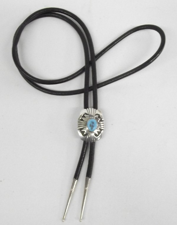 Bolo Tie Sterling Silver & Turquoise by T. Singer: Bolo Tie Sterling Silver & Turquoise by Tommy Singer. Black leather bolo with sterling tips, measuring 20''. The slide measures 1 3/4'' x 1'', turquoise cabochon is 1/2'' x 5/8''. Nicely etched design