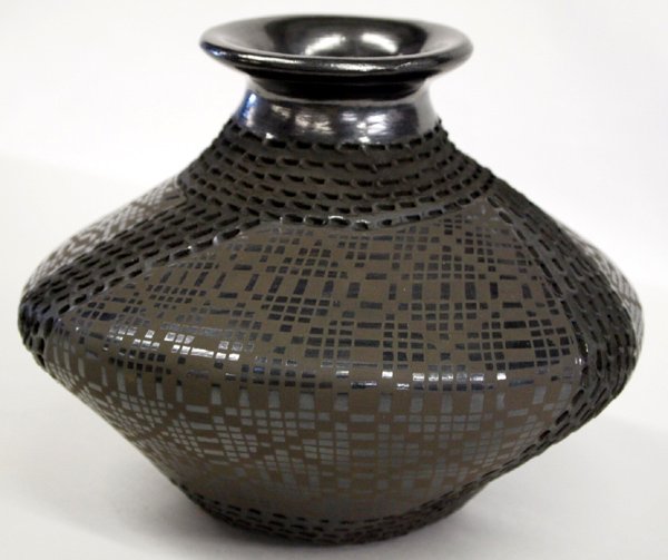 Mata Ortiz Textured Black on Black Jar - B Soto: Mata Ortiz Textured Black on Black Jar - B Soto. This jar has lines of indention designs and diamond eye-dazzler designs around the body. Signed on the bottom, Benjamin Soto. Measures 6''H x 8''W. Mat