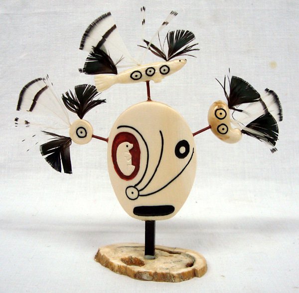 Inuit Ivory Totem Carving -- Eddy Syngoc: Inuit Ivory Totem Carving -- Eddy Syngoc (signed on bottom), sits on antler piece, features carved seal, ivory tooth, and circular ivory piece embellished with green, black, and white feathers, center