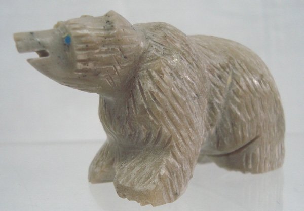 Zuni Bear Fetish -- Lucy Cooeyate: Zuni Bear Fetish by Lucy Cooeyate. Nicely carved Zuni stone fetish with surface texturing and turquoise inlaid eyes. It measures 1 1/2'' high x 2 1/2'' in length. Signed "LC"