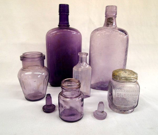 Antique Purple Glass: Antique Purple Glass Assortment. 2 whiskey pint bottles; a rare 1910's vintage Marvelous Cold Cream jar from Richard Hudnut, New York'' embossed on the front and in the tin lid. Approximately 3 1/2 in