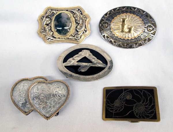 Collection of Belt Buckles: Collection of Belt Buckles. 1) Two- tone with a moss jasper cabochon in the center measuring 2.5''H x 3.5''W. 2) Thunderbird on oval buckle is 2.5''H x 3.5''W. 3)Rectangular brass Ampersand buckle wit
