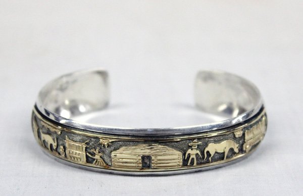 Navajo Sterling Silver 12KtGF Storyteller Bracelet: From the Collection of Nick and Suzanne Nicholas. Navajo Sterling Silver Storyteller Bracelet, gold overlay, inside measures 6in. which includes gap of .5in. wide, features hand stamping and Navajo fa