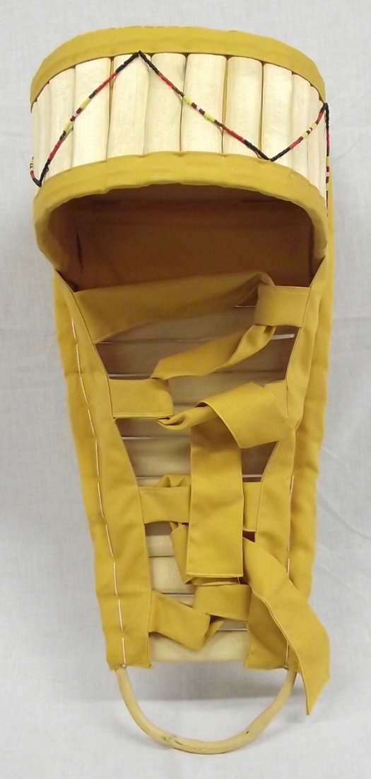 Apache Handmade Handpainted Cradleboard: From the Collection of Nick and Suzanne Nicholas. Apache Cradleboard, ocotillo wood, yellow cactus dye for the canvas straps and shade for the baby. Cradle boards are used frequently by the women, to 
