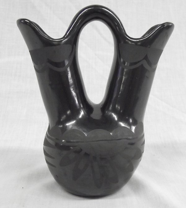 Tesuque Black on Black Wedding Vase Lorencita Pino: From the Nick and Suzanne Nicholas Collection we have a Tesuque Black on Black Wedding Vase by Lorencita Pino (1910-1980s), measures 5.75''H x 5''W, beautiful sun design amidst scalloped edging and ge