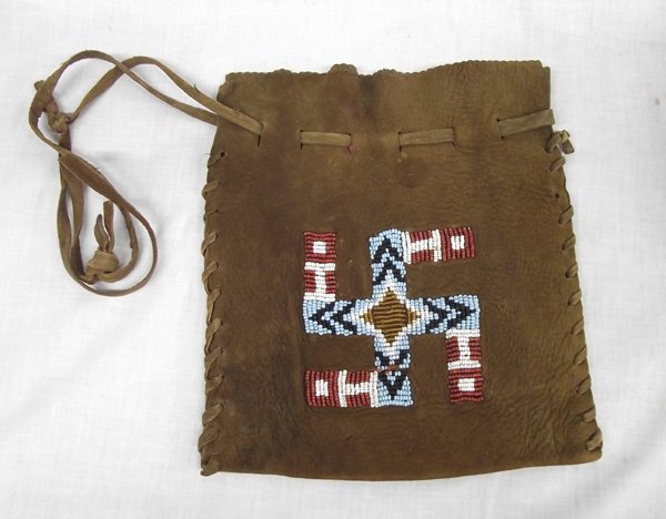 Jicarilla Apache Beaded Whirling Log Suede Purse: Jicarilla Apache Beaded Suede Purse. The Jicarilla Apache are from northern New Mexico. This attractive purse, with suede strap, has a beaded design on the front and measures approx. 9''H x 8''W with 