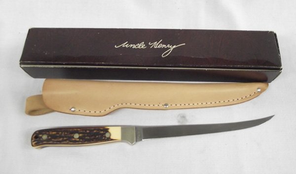 Schrade Cutlery Uncle Henry Knife and Sheath: Schrade Cutlery Uncle Henry Knife and Sheath. 12'' long with 7'' steel blade. Sheath measures 12 1/2''L x 1 5/8''W. Blade is marked ''Uncle Henry Shrade USA 167. Comes with registration form and loss 