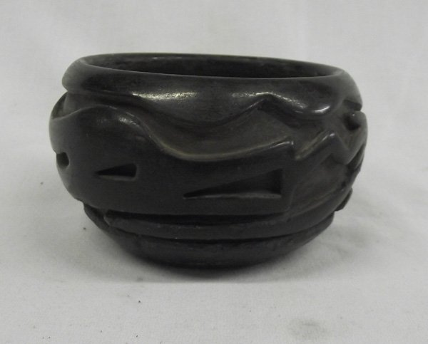 Santa Clara Carved Bowl by Teresita Naranjo: Santa Clara Carved Bowl by Teresita Naranjo. Vintage example of this noted Santa Clara Pueblo potter. Avanyu figure deeply carved into the piece which measures 3'' high x 5.25'' wide. Has some age wit