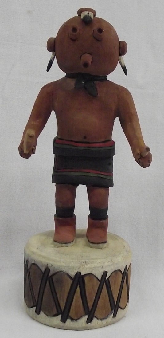 Hopi Mudhead Kachina by Jason Curley: From the collection of Nick & Suzanne Nicholas. Hopi Mudhead Kachina by Jason Curley, measures 8''h x 3.5''w. Native drum base, holding dance stick and rattle. Wood burned signature with eagle feather