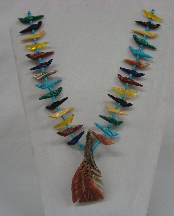Santo Domingo Carved Stone Bird Fetish Necklace: Santo Domingo Bird Fetish Necklace. Fifty carved bird fetishes complete this necklace, separated by turquoise heishi beads. The central figure is fashioned from an abalone shell and measures 3 1/4'' x