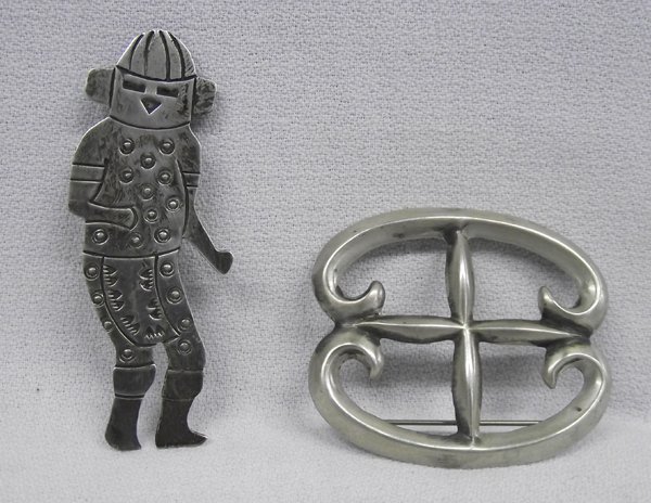 Pr Navajo Sterling Pins One by Douglas Etsitty: Two Sterling Silver Pins. Sterling Hopi Kachina pin by Douglas Etsitty, measures 2.5'' x 1'', signed. Sand cast pin measuring 1.5'' x 2'' wide, marked ''Sterling''.