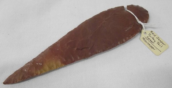Red Jasper Stone Spearhead Replica Eiserman Estate: Red Jasper Stone Spearhead from Eiserman Estate. Tag on arrowhead reads, ''Red Jasper Turkey Tail Spear - Tishimingo Co., Mississippi''. Origin & Date Unknown on this item. Measures approx. 8''L x 2.2