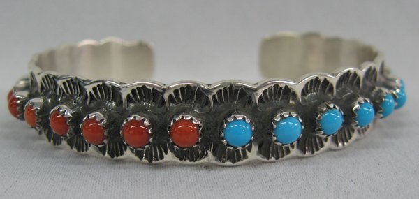 Turquoise, Coral and Sterling Bracelet - T. Jon: Turquoise, Coral and Sterling Bracelet, Signed. Sixteen round cabochons are set against a stamped background. Marked ''Sterling'' ''T Jon''. Measures 6.5'', including opening, .5'' wide.