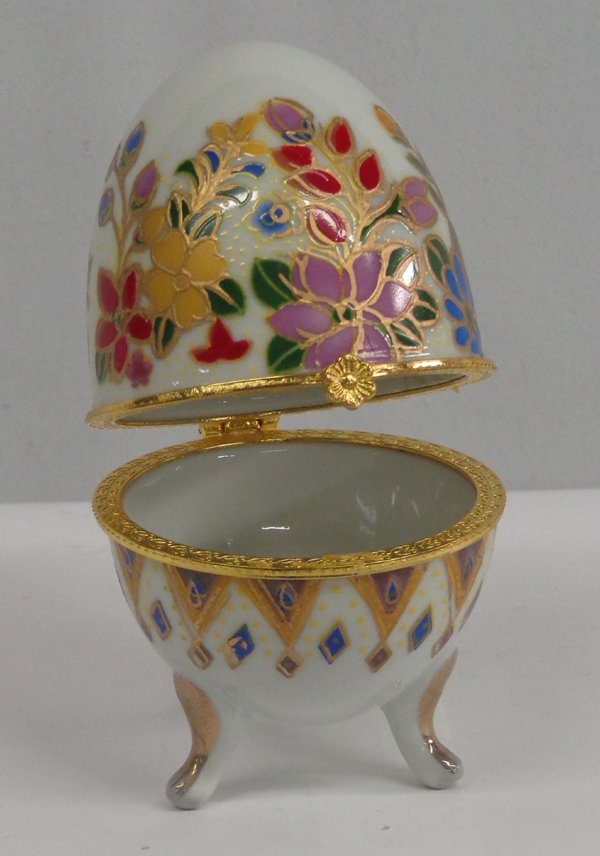 Russian Porcelian Decorated Egg Trinket Box: Russian Porcelian Decorated Egg Trinket Box. Hinged and footed egg trinket box, hand-painted and embellished with gold. Measures 4'' x 2.5''.