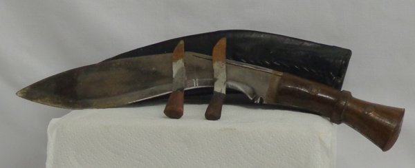 Kukri Knife from Nepal with Two Smaller Knives: Kukri Knife from Nepal with two smaller knives. The smaller Knives are called Karda and ChakmakThe Large Knife Measures 16.5'' long, 2.5'' wide with leather stitched sheath and 2 small knives.