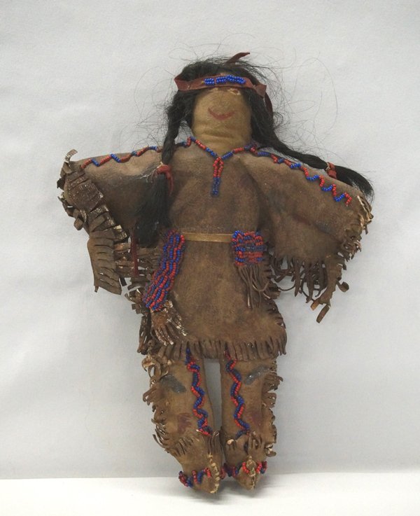 Vintage Plains Indian Doll in Rawhide Clothing: Vintage Plains Indian Doll in Rawhide Clothing, measures 12''H x 8.5''W, aged rawhide beaded leather top and pants, real hair with leather headband and ties on braids, face is painted on