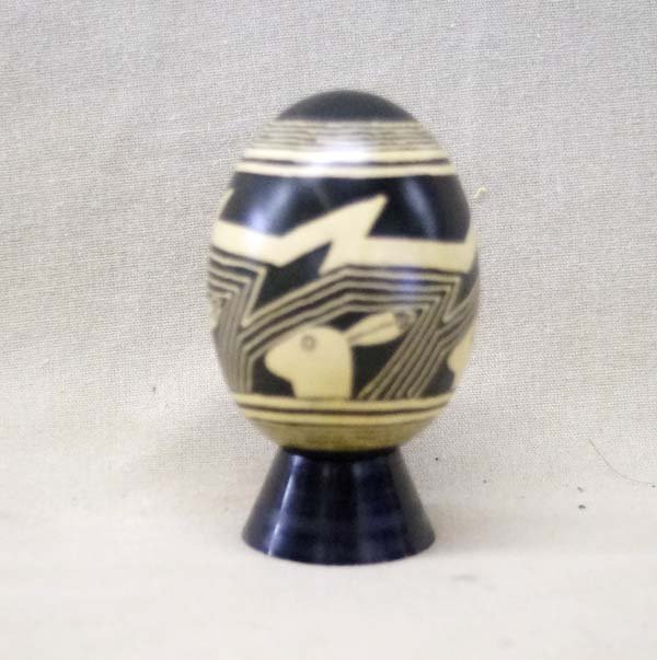 Hand Painted Mimbres Rabbit Design Egg: Hand Painted Mimbres Rabbit Design Egg. This natural piece is a brown egg shell will black Mimbres Native American Rabbit designs. By New Mexico Artist Patricia Dix it includes stand and box.