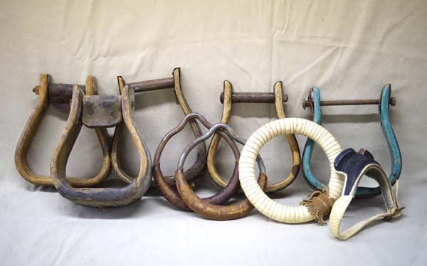 Collection of Vintage Cowboy Stirrups: Collection of Vintage Cowboy Stirrups. We have a set of round leather covered metal stirrups, and various single stirups. The largest of these measures approx. 8'' x 2.5''. The metal pair is 5.5'' x 6