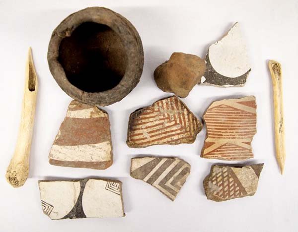Prehistoric Mimbres Pottery, Sherds, Stone Carving: Prehistoric Mimbres Pottery, Sherds, Stone Carving, and Bone Awls, largest measures 3'' x 3'', includes small corrugated pottery jar (missing rim pieces), 2 bone awls, 7 pottery sherds, and a carved s