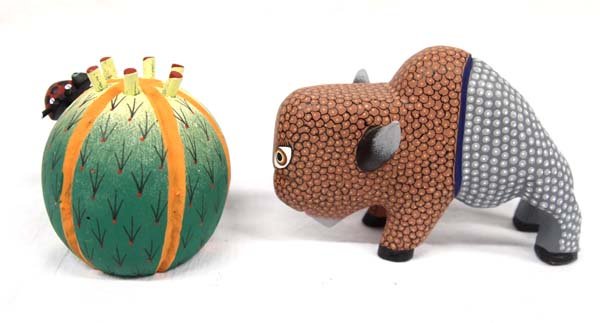 2 Mexican Oaxacan Alebrije Figures: 2 Mexican Oaxacan Alebrije Figures, largest measures 5''L x 3.25''H x 1.5''W, includes a buffalo by Isaac Fabian and a barrel cactus and ladybug by G.T.V., both are vibrantly painted and signed by art