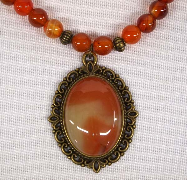 Southwestern Striped Carnelian and Bronze Necklace: Southwestern Striped Carnelian and Bronze Bead Necklace, measures 17'' end to end, bronze beads, setting, and clasp, pendant measures 1.5''L x .75''