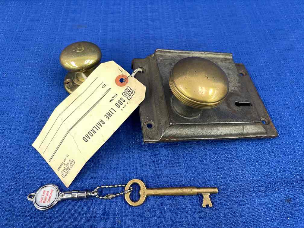 Caboose Door Handle: Caboose Door Handle, Cast & Brass with brass key, No visible markings, It is said to have come off a Soo Line Caboose, Key is stamped Adlake, No square shaft on knobs.