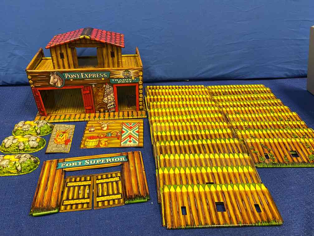 T. COHN Fort Superior Pony Express Tin Toy: 28 pieces, Superior Toy mfg. T. Cohn Inc. New York City. Very Nice, 2 pieces slightly faded, patent pending, 2 tabs on upper deck are missing. Fence pannels are double sided.