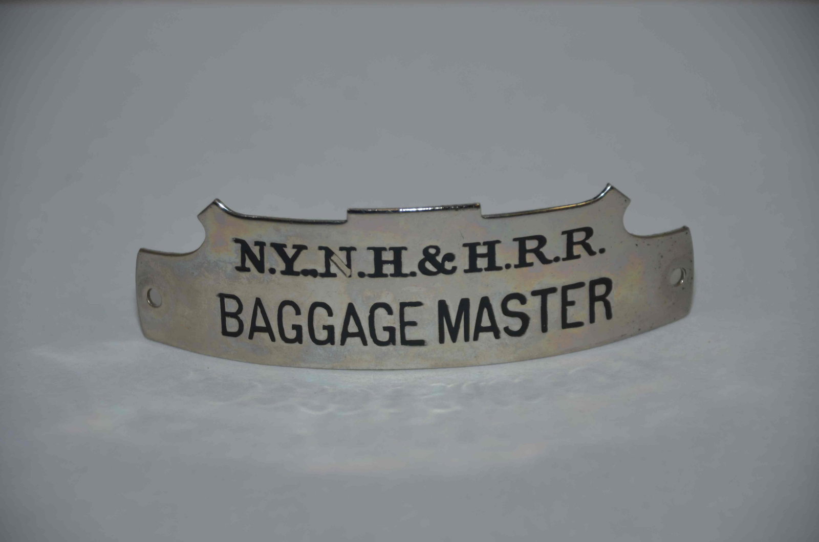 New York New Haven and Hartford RR Baggagemaster Hat Badge: This is a New York New Haven and Hartford Railroad baggagemaster hat badge. Very nice original condition, with a little bit of wear on the black in the second N. A hard to find badge that is in demand