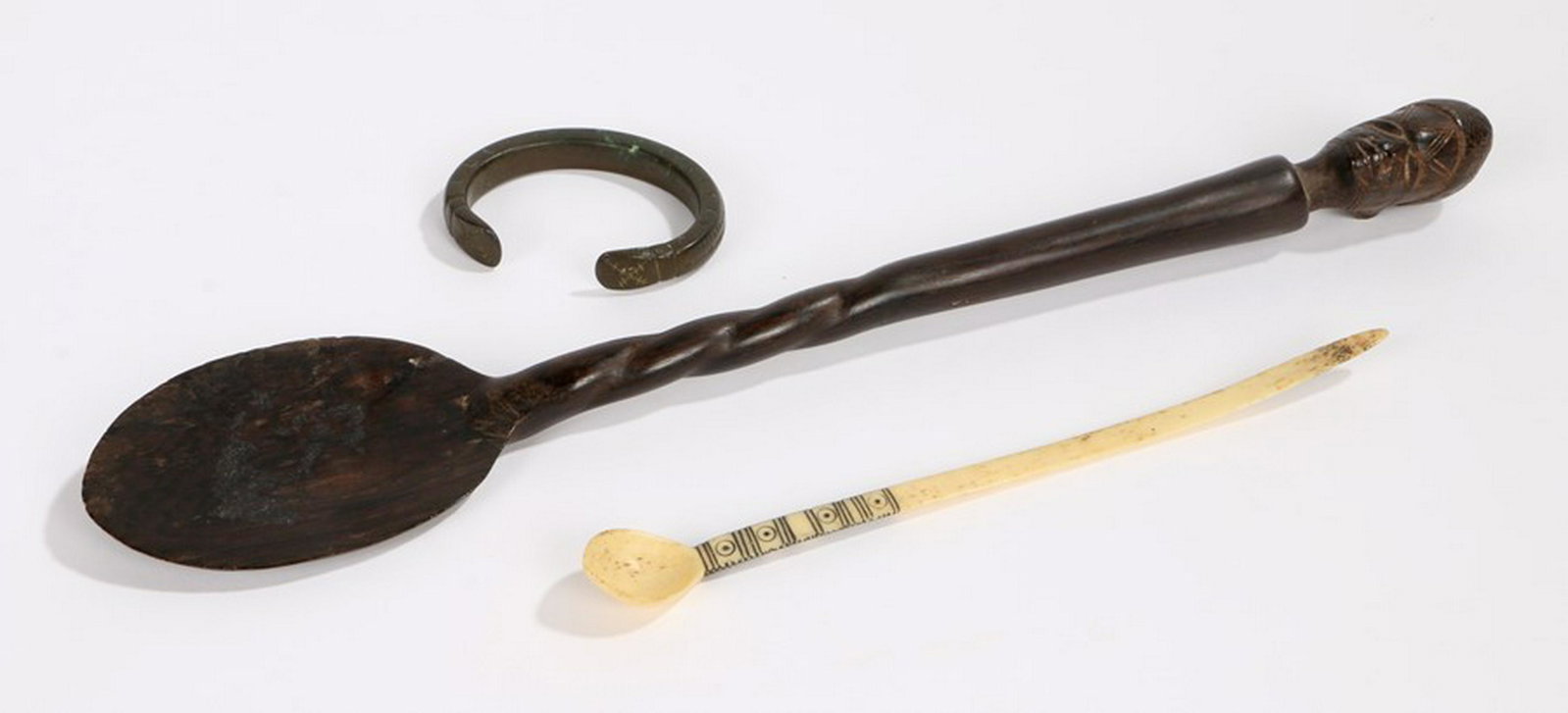 South African spoons, carved with a head to the top, a: South African spoons, carved with a head to the top, a bronze bracelet with chisel and punch decoration width 6.5cm, and an Africa bone spoon, (3) - Stock Ref:6433-66