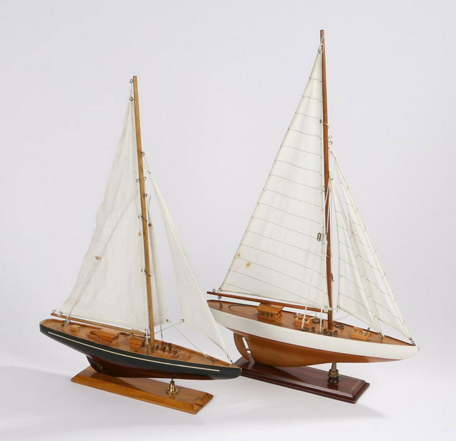 Two models of yachts, the first with a white and wood: Two models of yachts, the first with a white and wood hull, sails raised, the second with a blue and wood hull also with sails raised, 42cm long - Stock Ref:4754-45