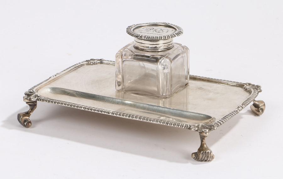 George V silver desk stand, London 1921, maker Charles: George V silver desk stand, London 1921, maker Charles Stuart Harris, the silver mounted glass inkwell engraved PRJ Sept 4th 1969, the stand with pen tray, scroll and gadrooned border, raised on reede