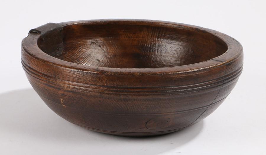 19th Century turned bowl, with ring turned edge, with: 19th Century turned bowl, with ring turned edge, with an iron strap repair to the top edge and staple, the base with the initials LM, 23cm wide