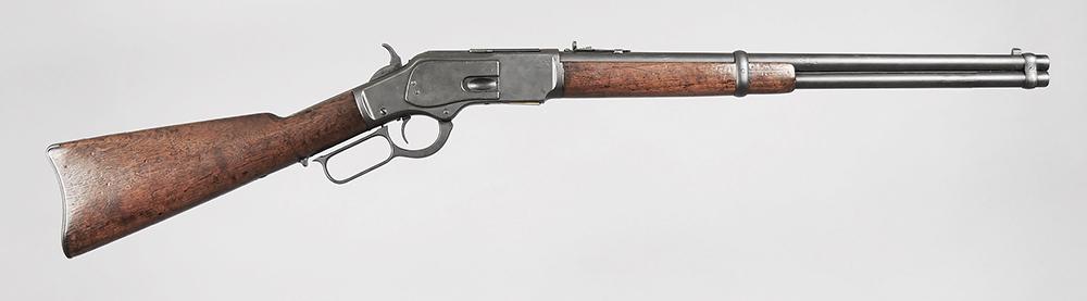 Winchester 1873 Saddle Ring Carbine: .38-40, S/N 323021B (1889), 20 in. barrel, 12-7/8 in. LOP, integral dust rail on top of receiver, straight grip stock, iron buttplate with compartment (lacking cleaning rod), saddle ring on left side 