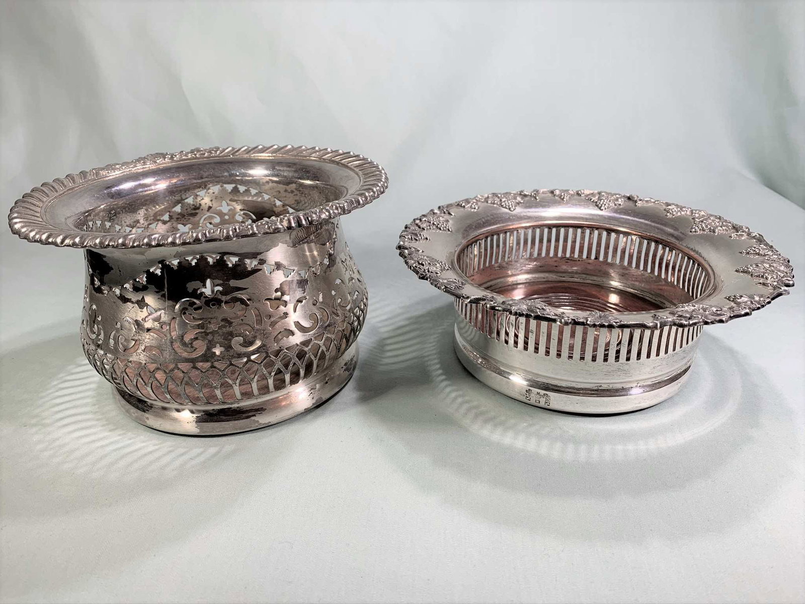 Two English Silver Plate Wine Coasters: Two Vintage Reticulated English Sheffeild Silverplate Wine Coasters. One has hallmarks to base. Normal cleaning necessary. Tallest measures 4-1/4" H x 7' diameter, 2-3/4" H x 7-1/2" W.