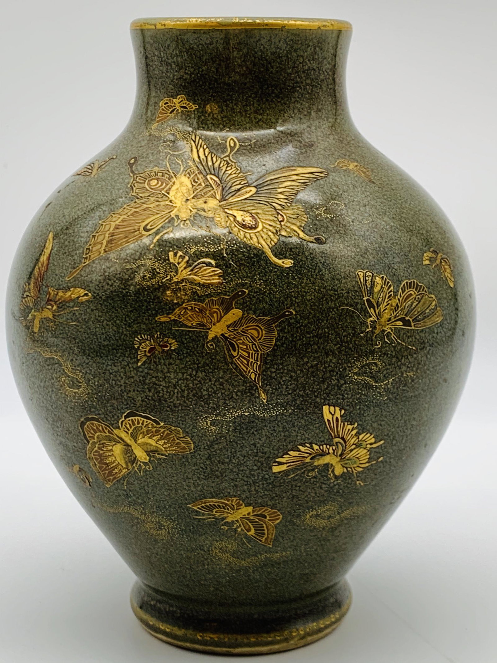 Antique Japanese Porcelain Gilt Decorated Vase. The: Antique Japanese Porcelain Gilt Decorated Vase. The dark olive green ground decorated with hand painted gilt fluttering butterflies. Signed with character marks in cartouche on side. Good condition. M