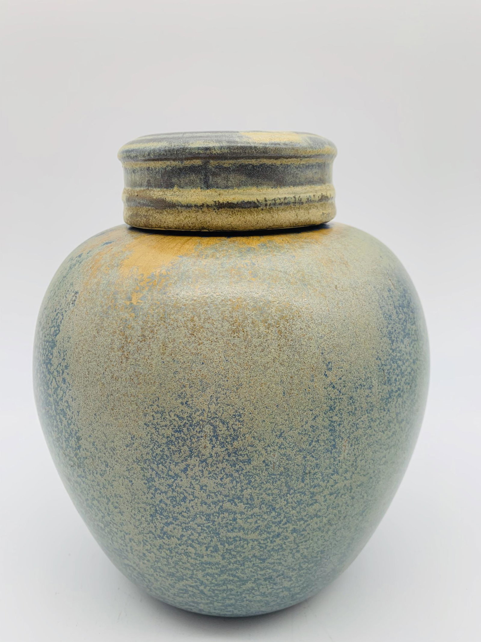 Style Of University City Pottery Covered Jar: In The Style Of University City Pottery. Glazed covered Jar. Raised dots on bottom possibly a mark/signature. Good condition. Measures 8" H x 7" W.