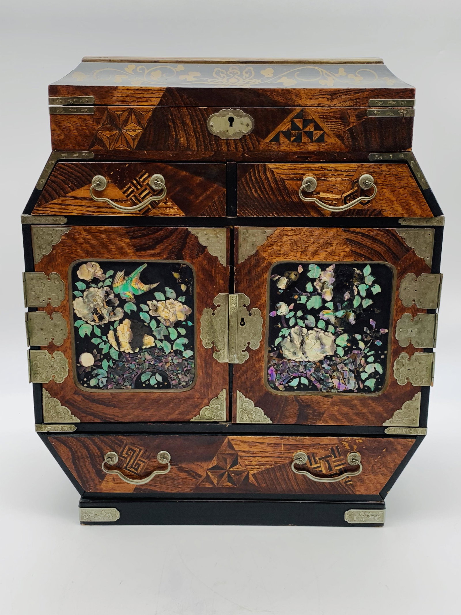 Japanese Meiji Inlaid Jewelry Cabinet: Japanese Meiji Inlaid Jewelry Cabinet. Likely used for jewelry and or personal accouterments. Metal mounts, inlaid wood designs and Mother Of Pearl Decorations. Multiple drawers and compartments. Unsi