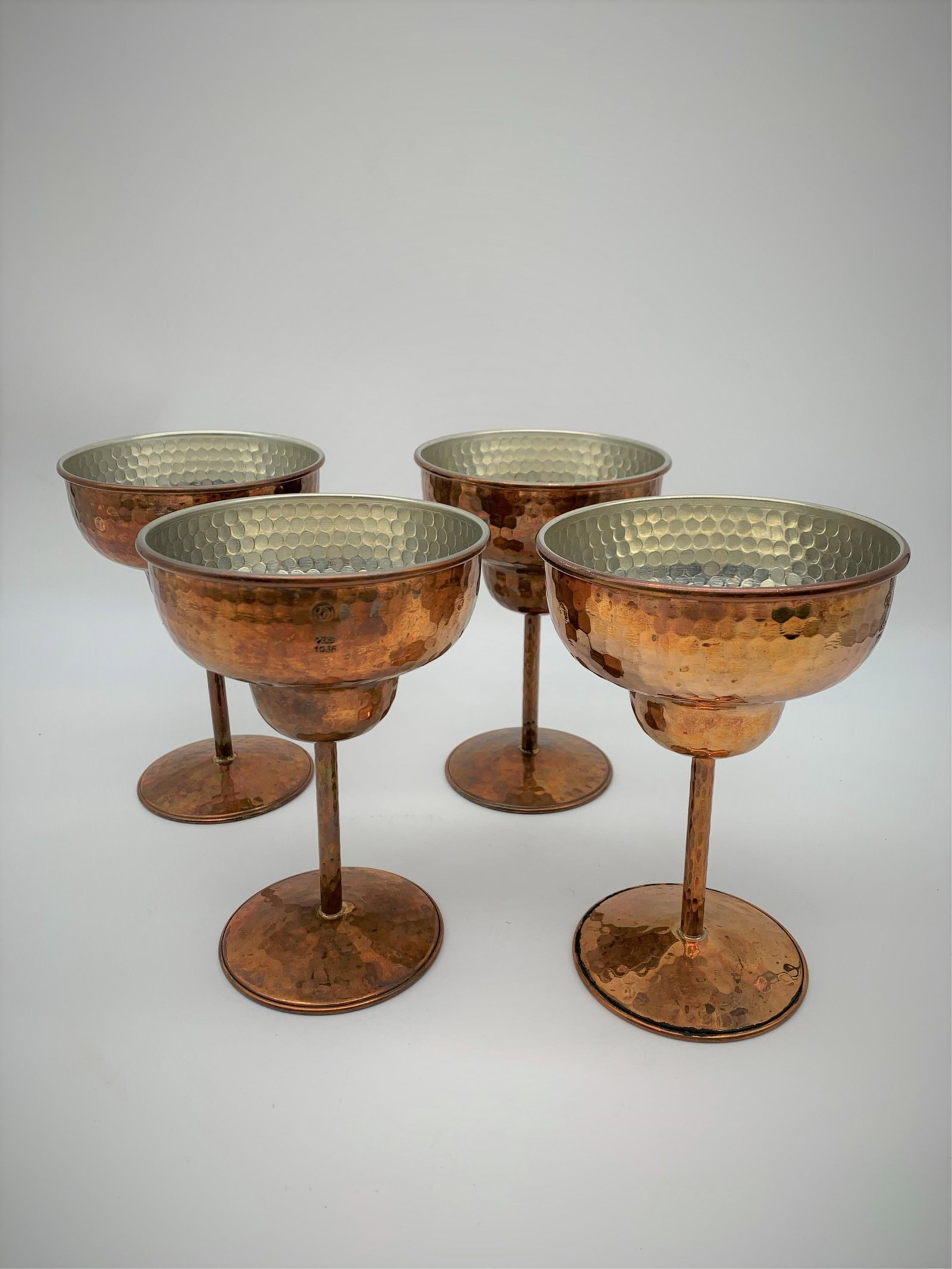 4 Hand Hammered Copper Guild Margarita Glasses: 4 Vintage Hand Hammered Copper Guild Margarita Glasses. Marked with Logo, WS 1956. In need of cleaning or in good condition. Measures 6-1/4" H x 4-1/2" W. Third party shipping.